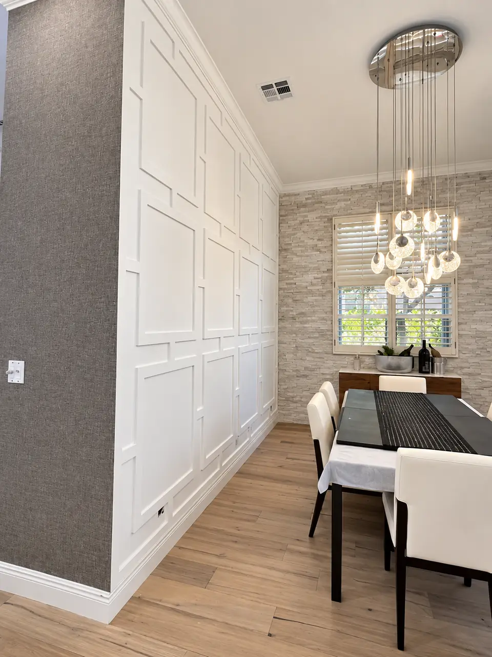 Full-height paneled wall beside a dining table