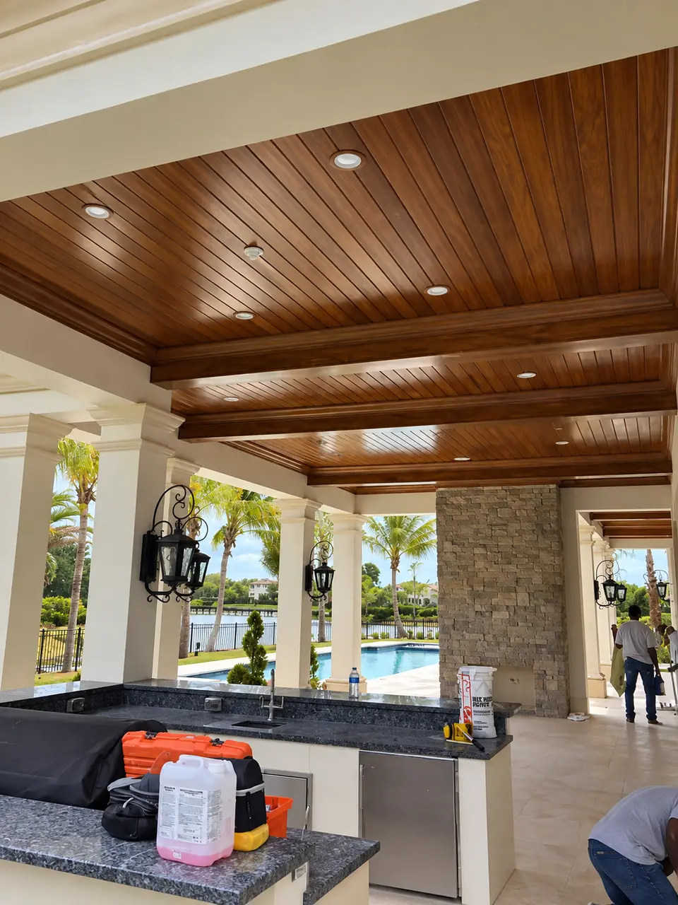 Stained tongue-and-groove wood ceiling with beams over a covered outdoor living area